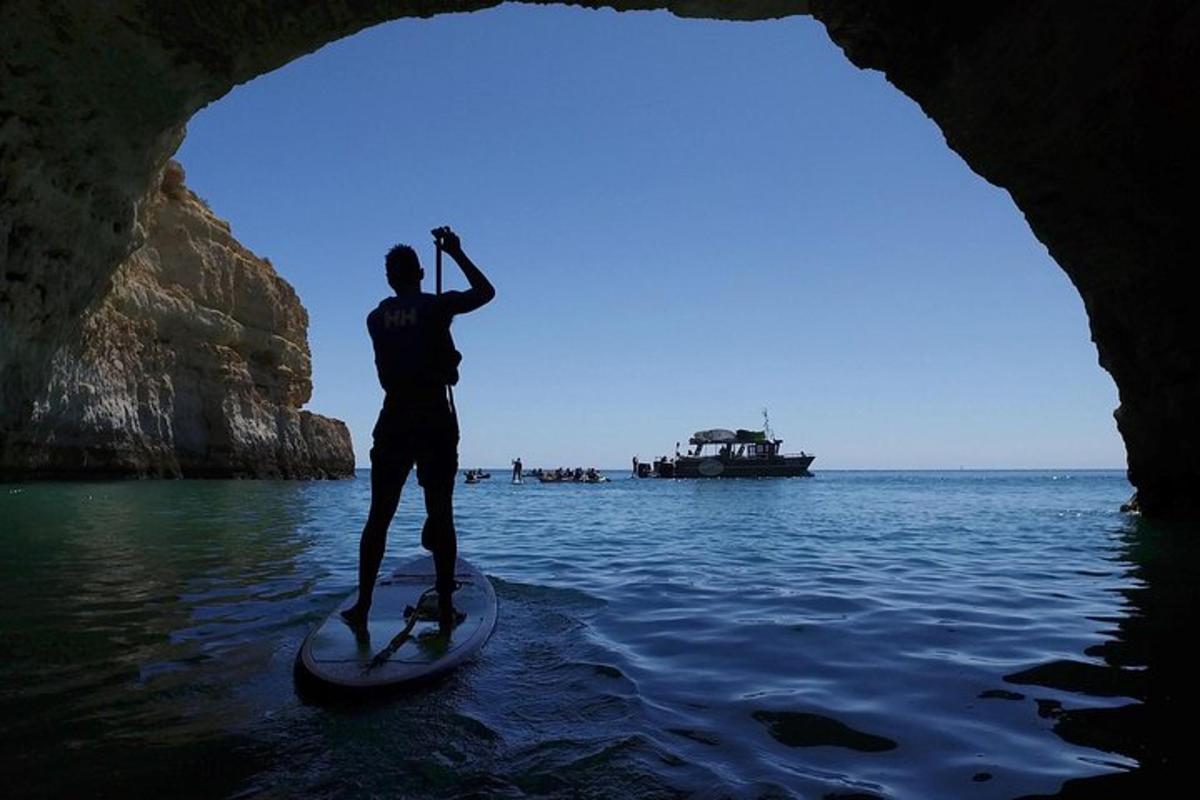 moški, ki stoji na deski za veslanje v vodi