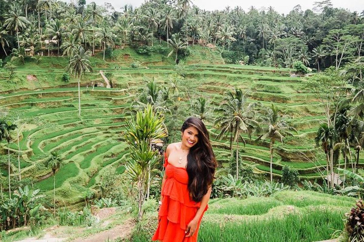 uma mulher de vestido laranja em pé em frente a um campo