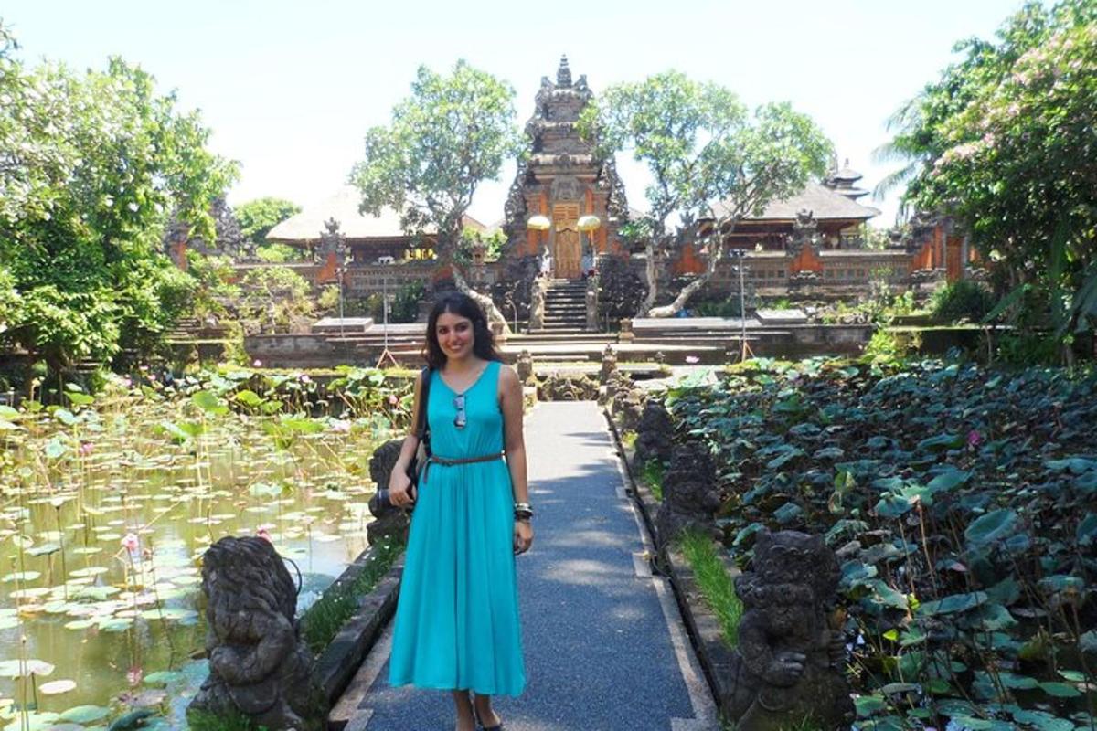 eine Frau in einem blauen Kleid steht vor einem Teich