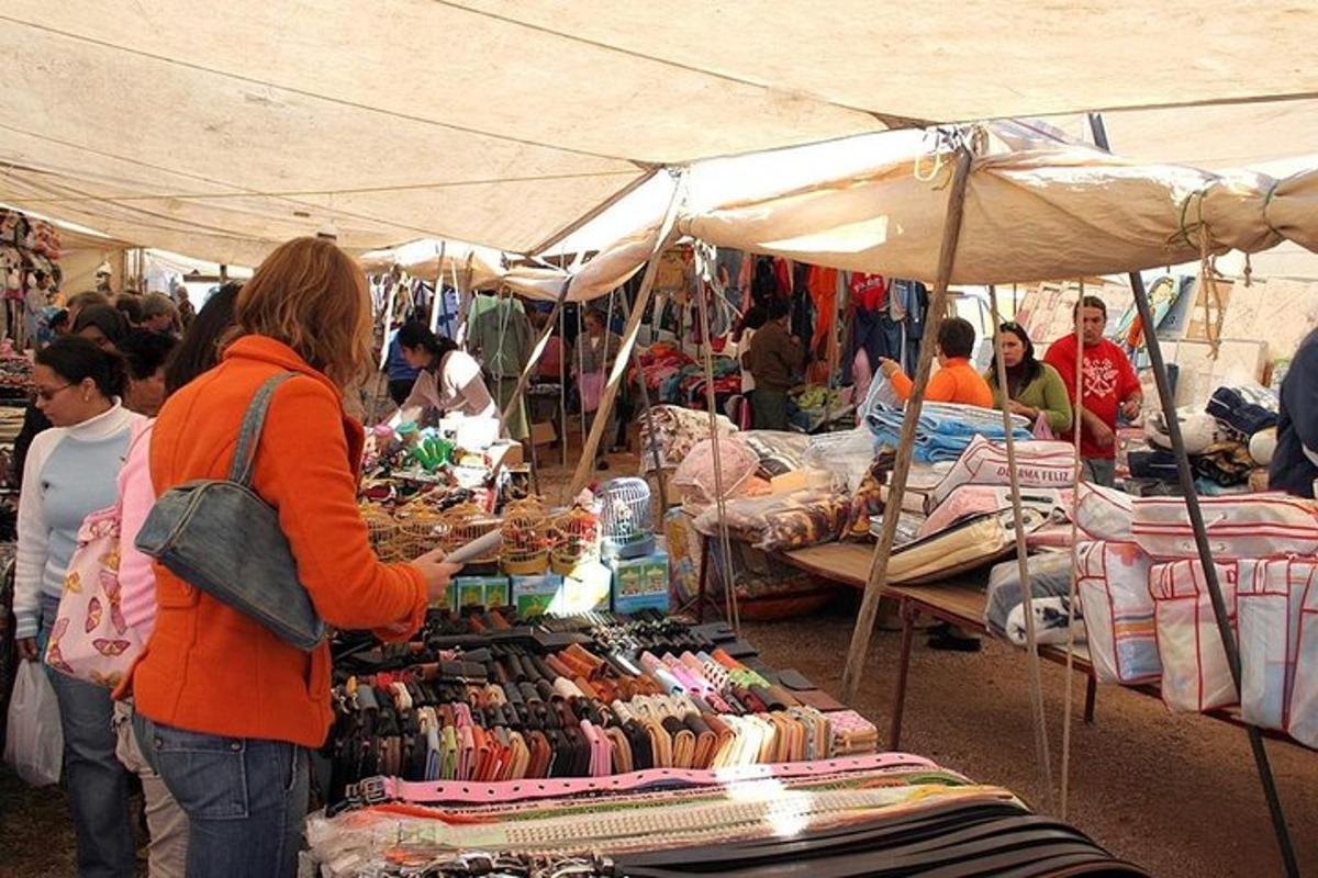 un gruppo di persone in piedi intorno a un mercato con una donna in piedi davanti