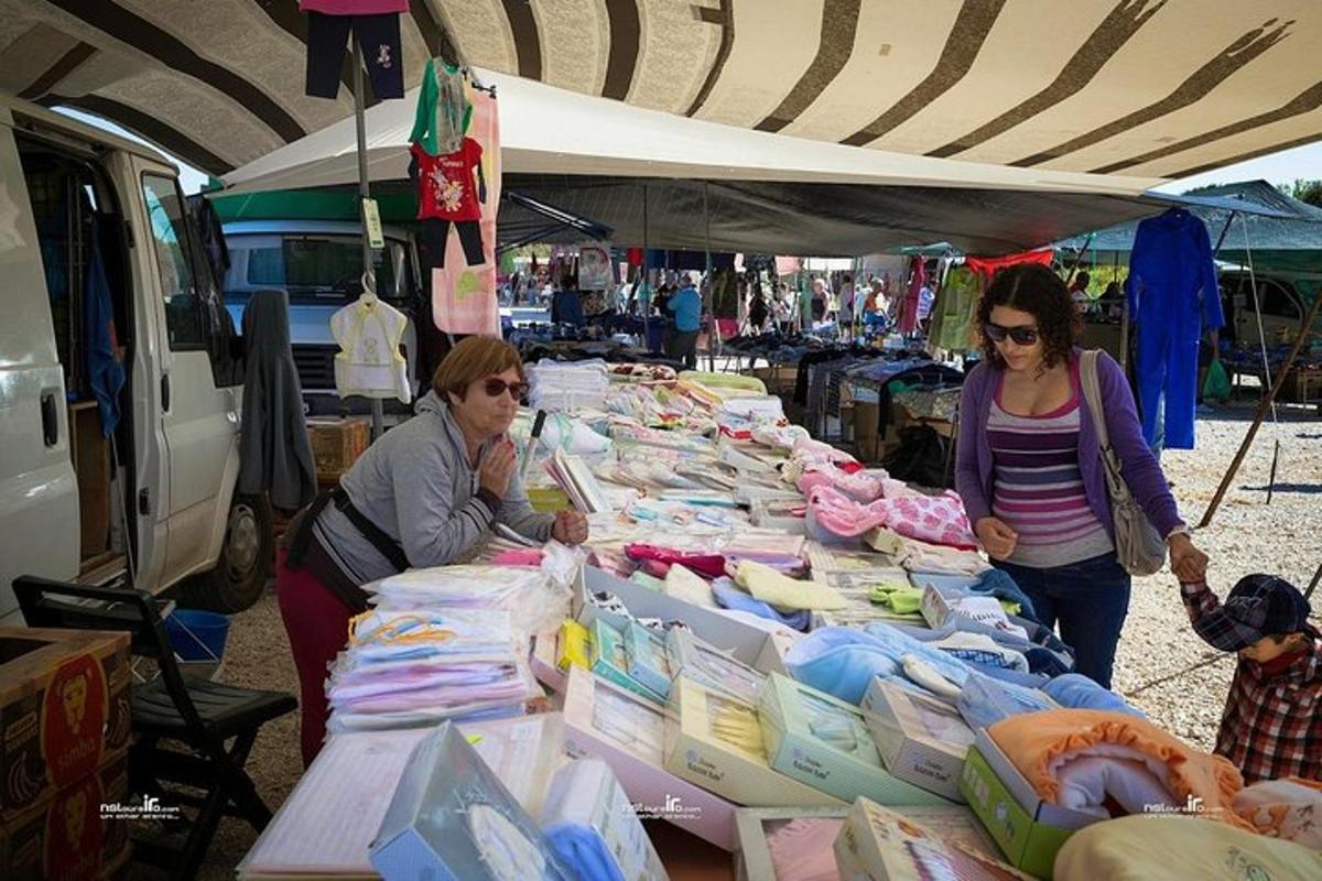due donne in piedi davanti a un tavolo pieno di merce