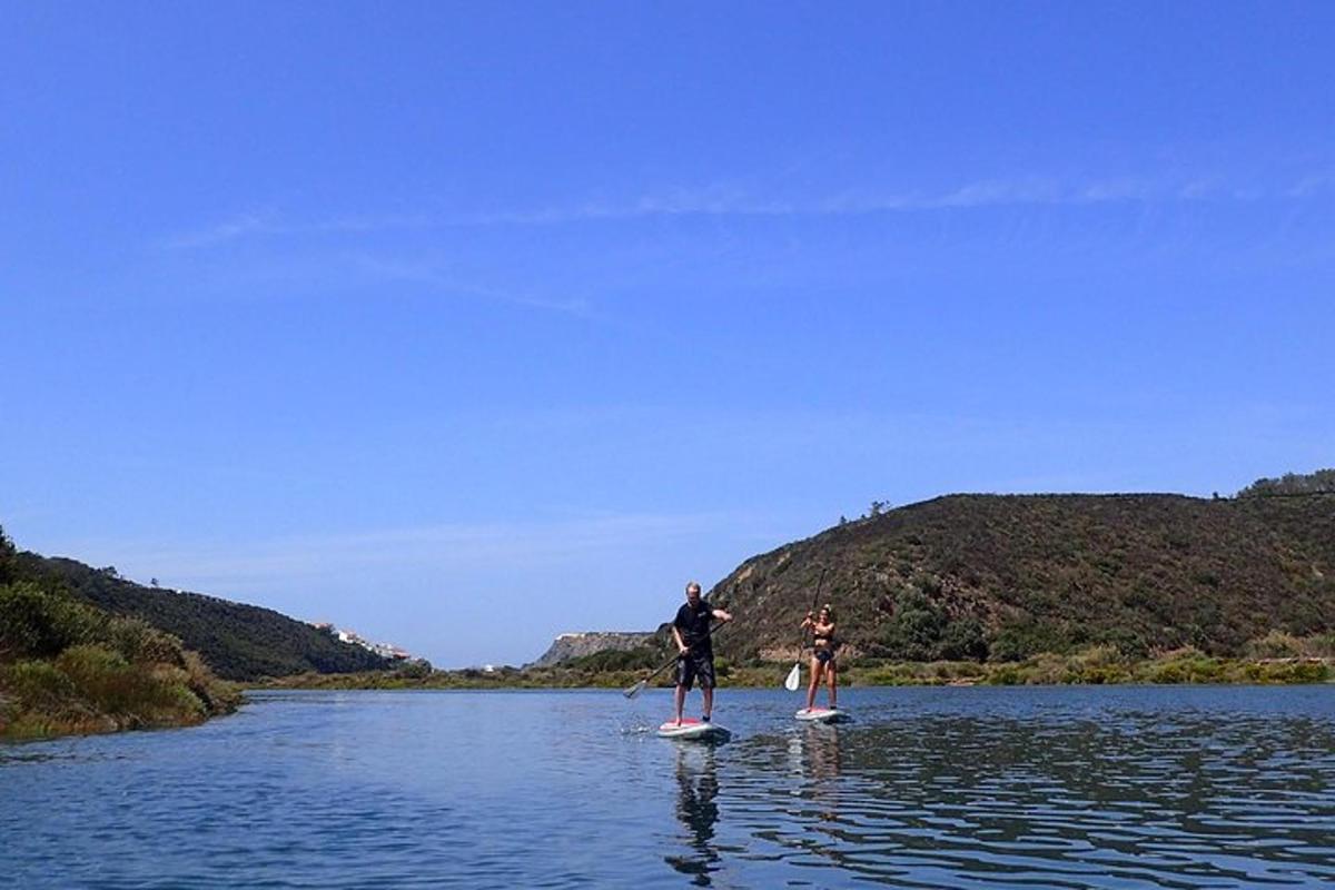 two people are standing on paddle boards in the water