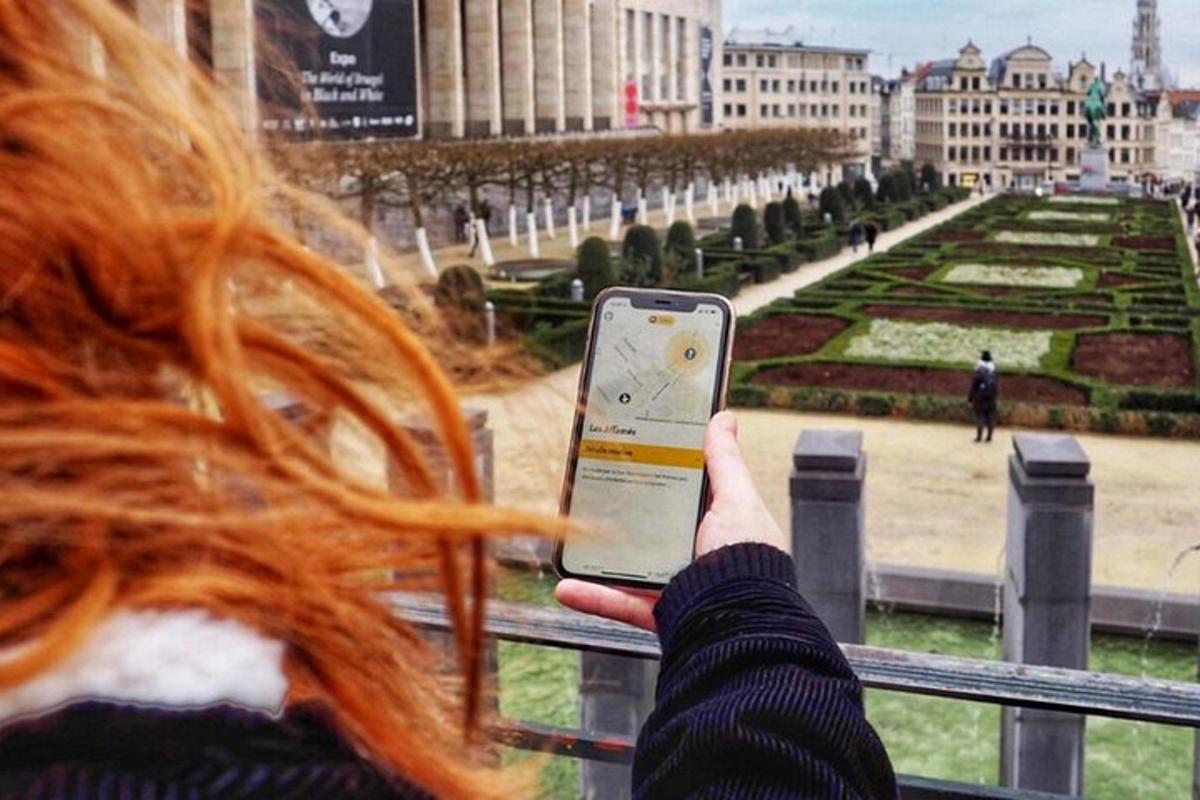 a woman holding up a cell phone to look at a park