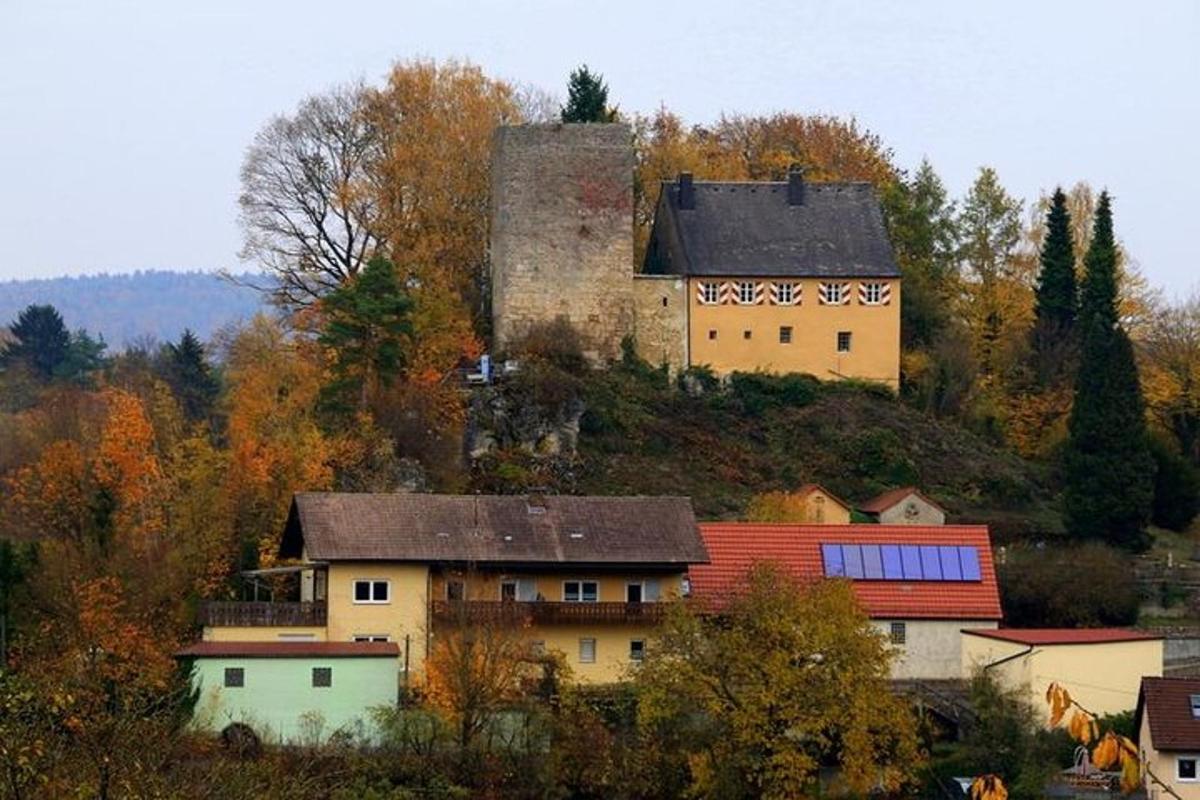 una casa al cim d'un turó amb un castell