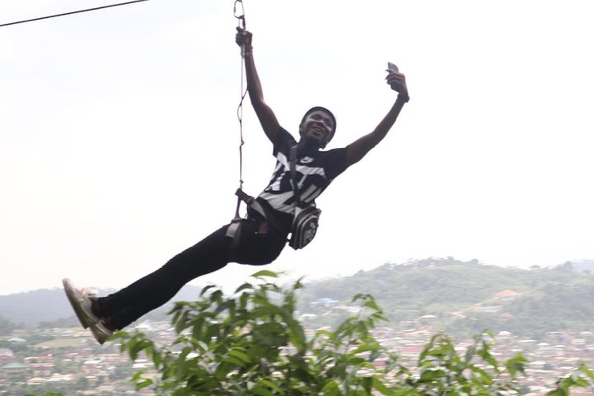 seseorang sedang bergelantungan di tali zipline