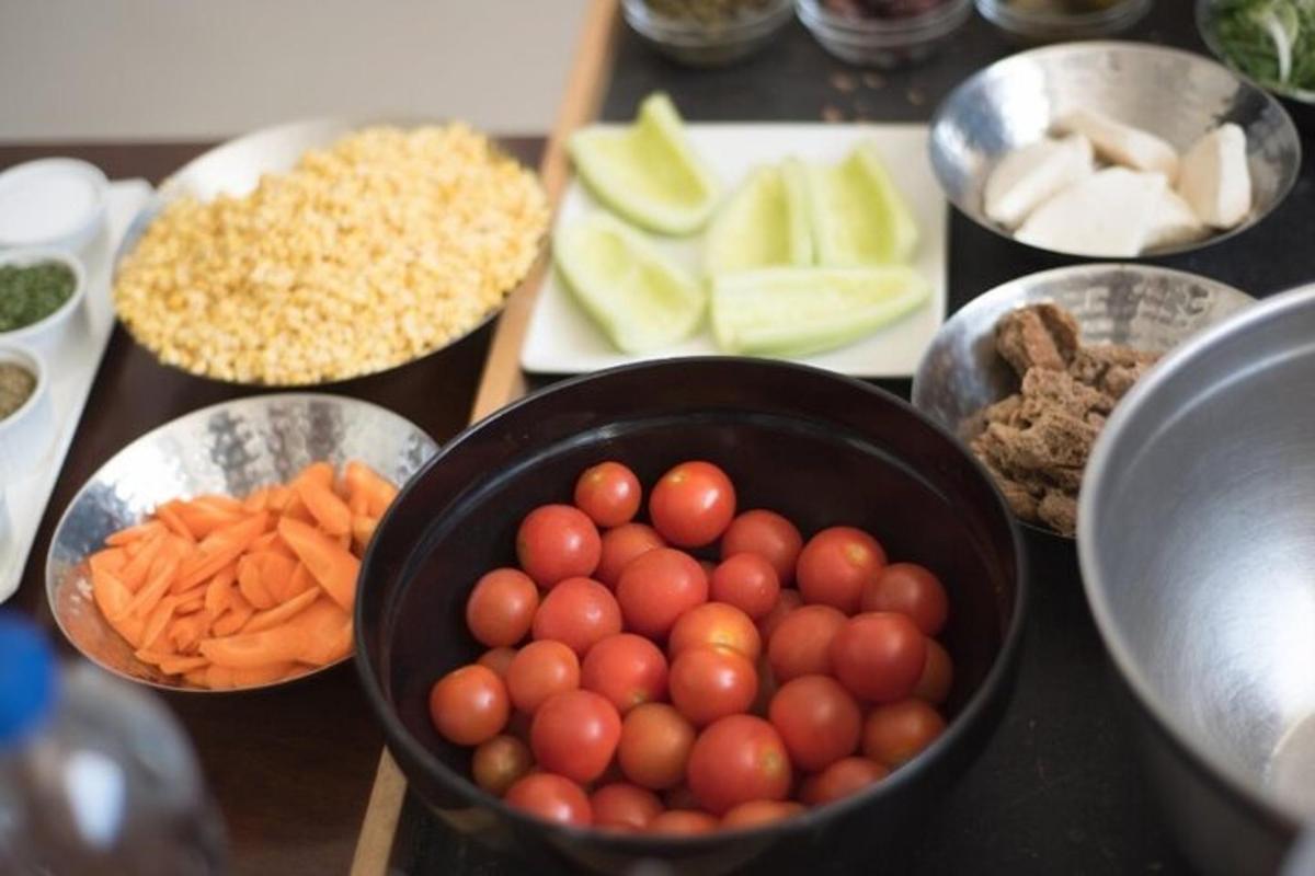 meja dengan semangkuk tomato dan sayur-sayuran lain