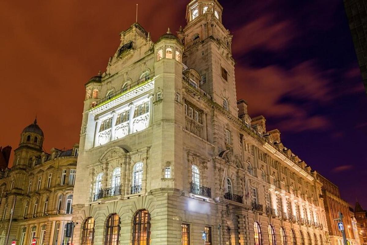 Un gran edificio con una torre de reloj por la noche.