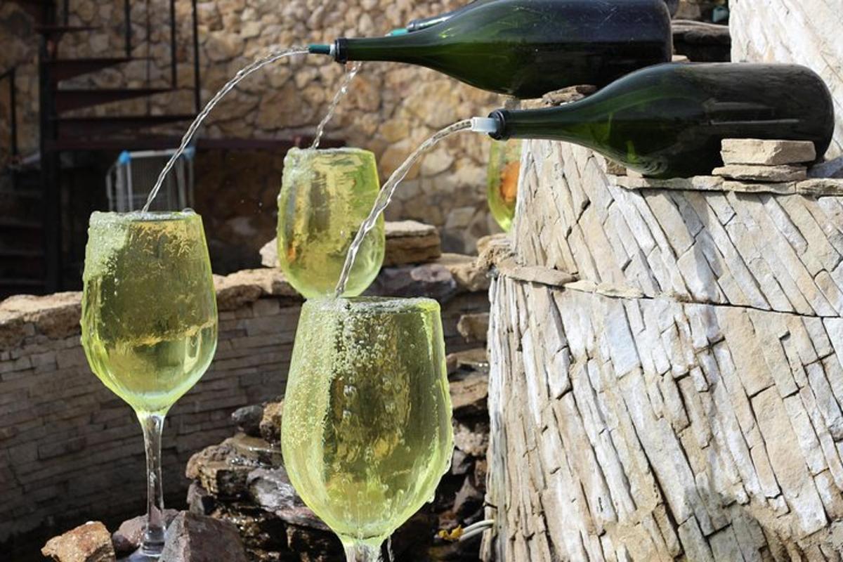 tre bicchieri di vino sono appoggiati su alcune rocce