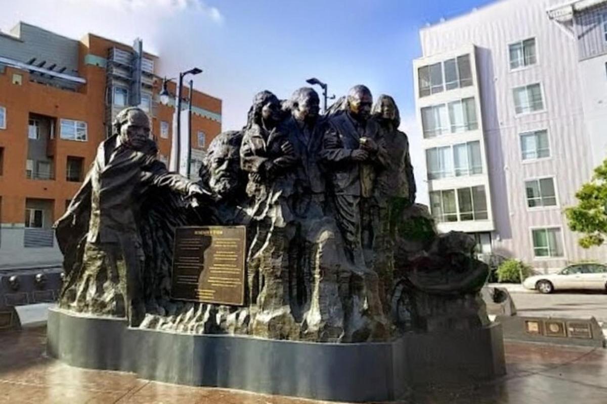 una statua di un gruppo di persone in piedi su un monumento