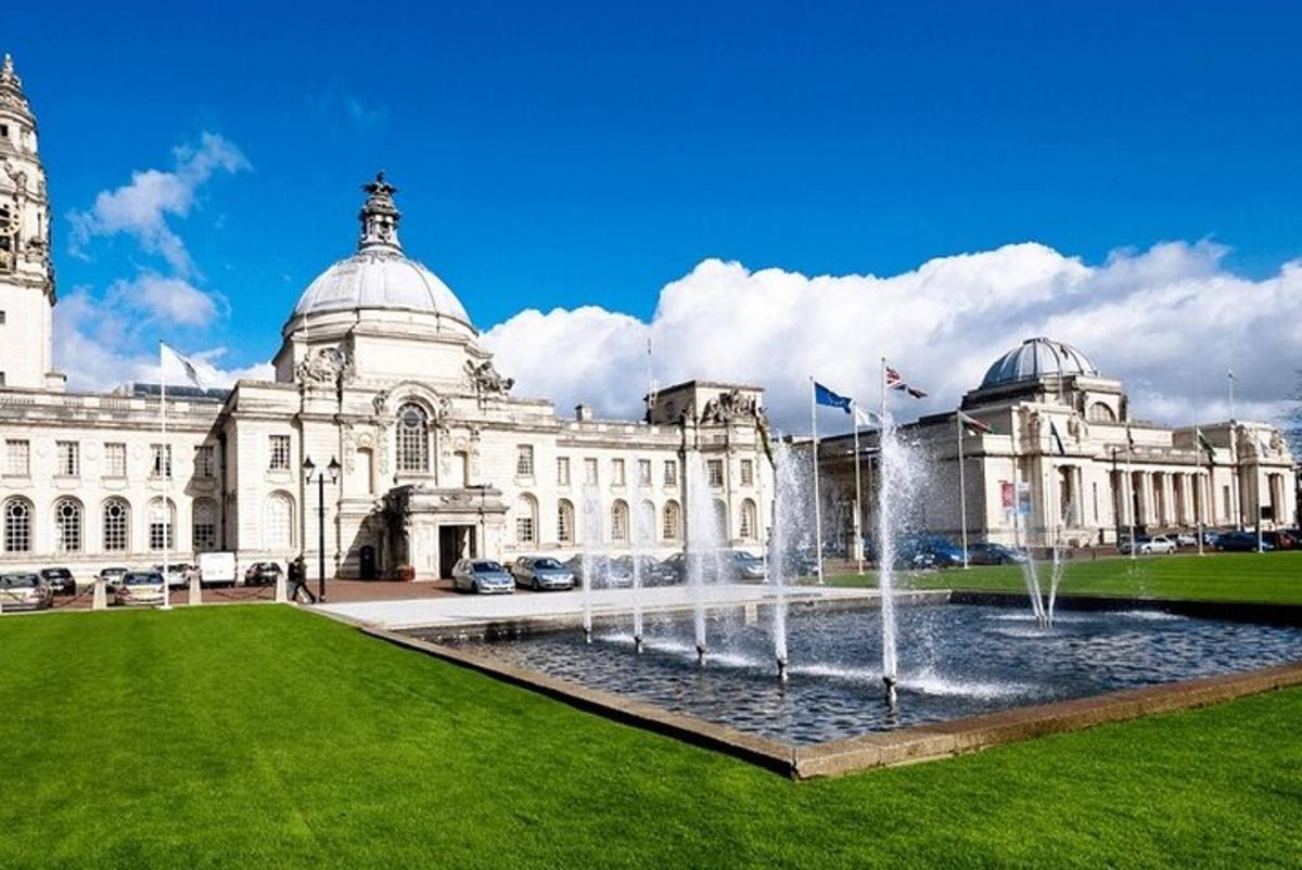 un grande edificio con una fontana di fronte