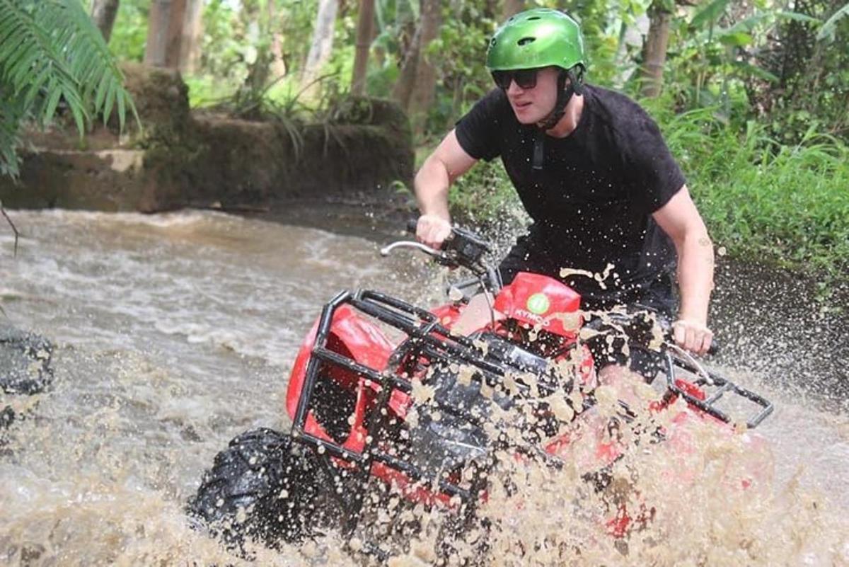 seorang lelaki menaiki atv melalui sungai