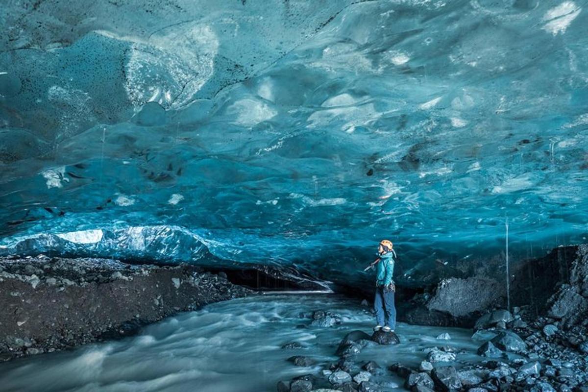 a person standing in front of an ice cave