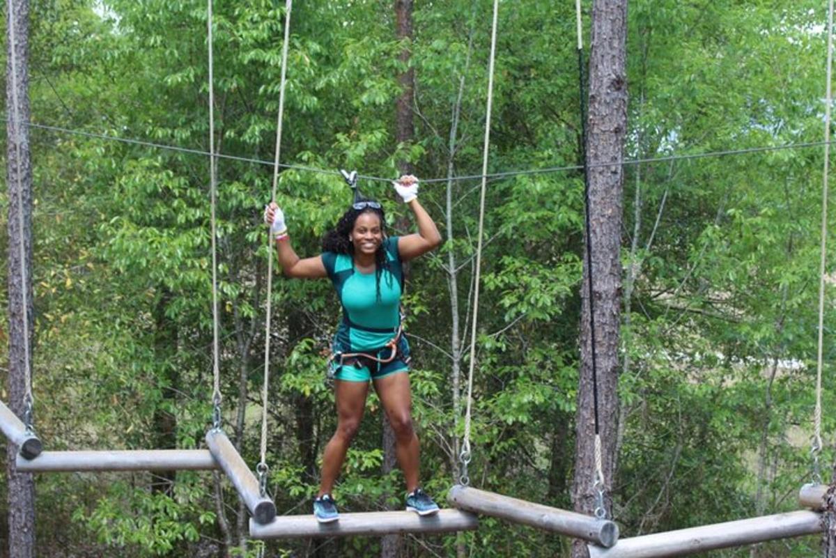 a woman on a zip line in the forest