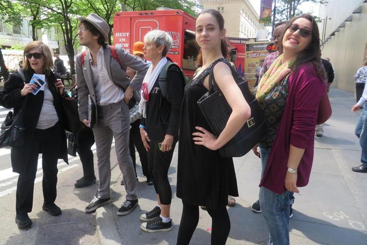 un grup de oameni care stau pe o stradă a orașului