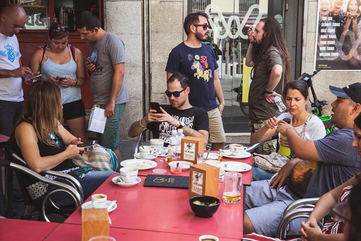 egy csoport ember ül egy asztal körül a mobiltelefonjaikkal