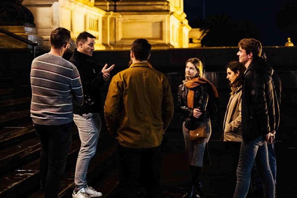 skupina lidí stojících v noci na ulici