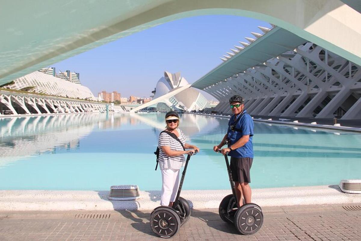 muž a žena jedoucí na segwayích pod mostem