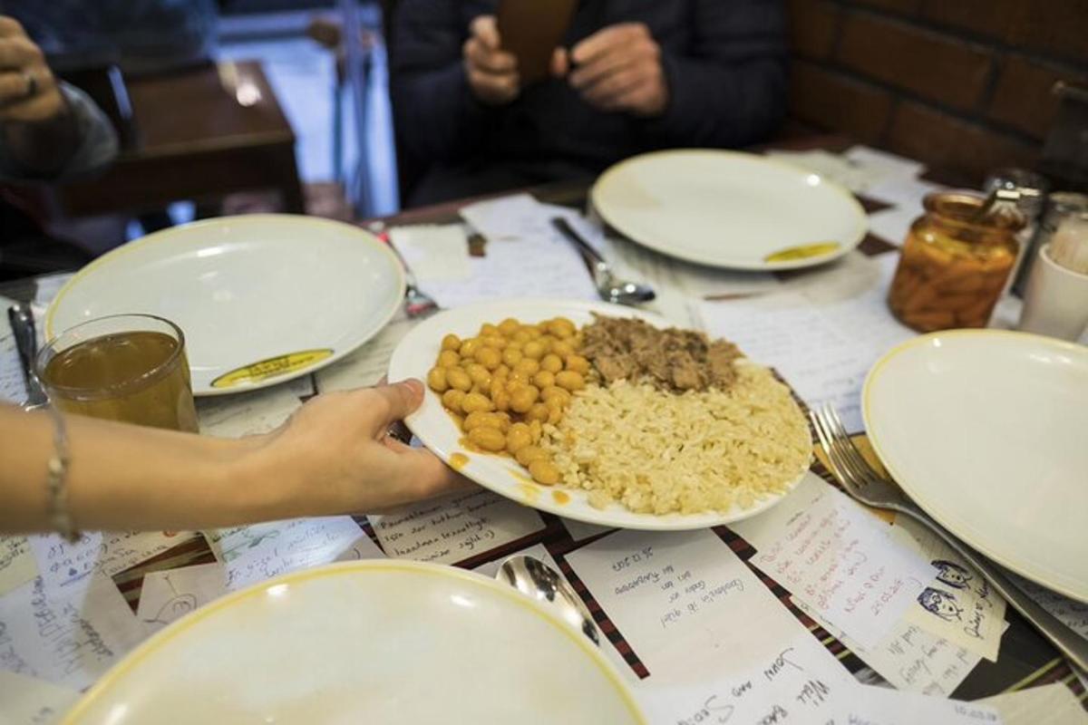uma pessoa segurando um prato de comida sobre uma mesa