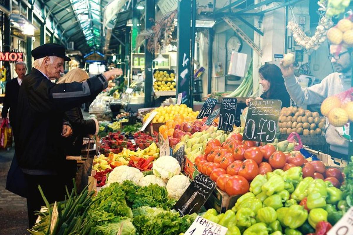 גבר עומד בשוק עם תצוגה של פירות וירקות