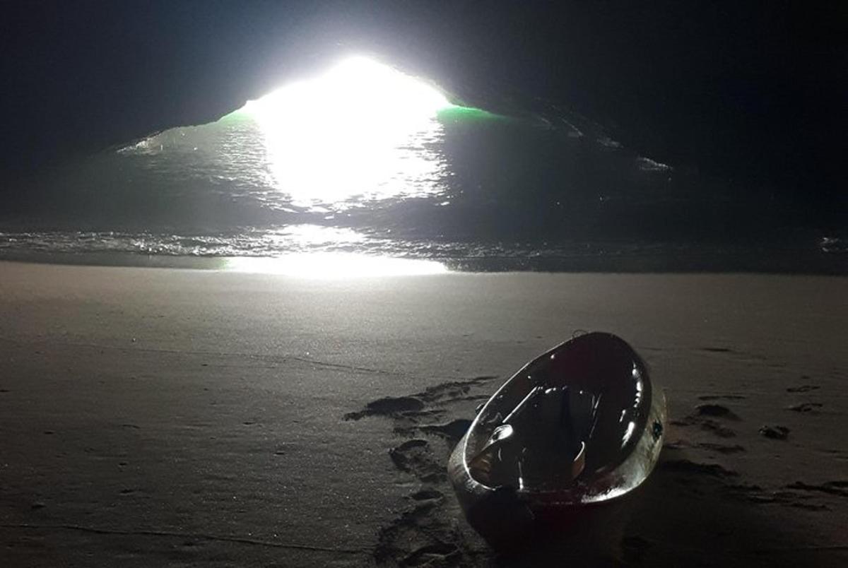a object on the beach with the sun in the background