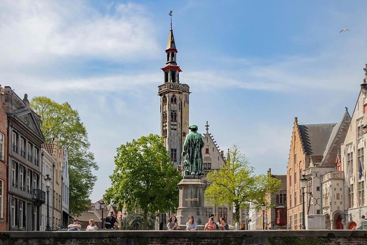 una torre dell'orologio con una statua al centro di una città