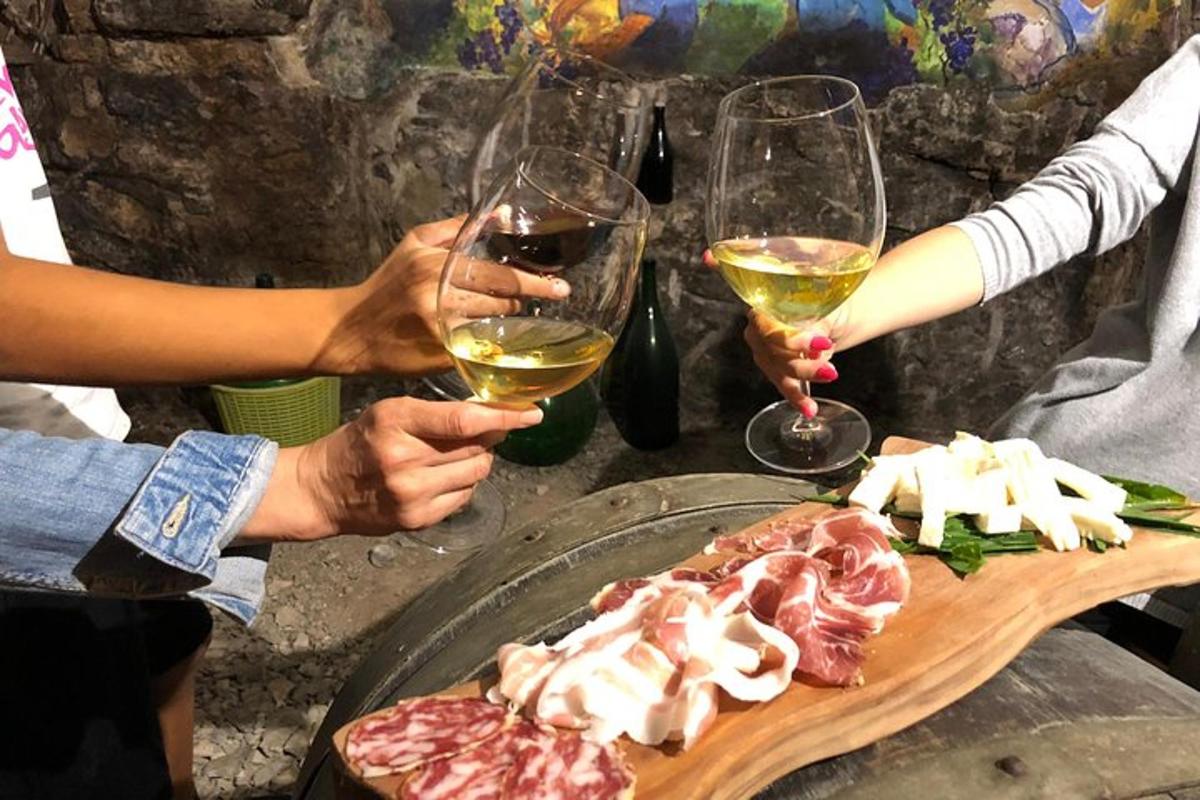 un gruppo di persone che tengono in mano bicchieri di vino e cibo