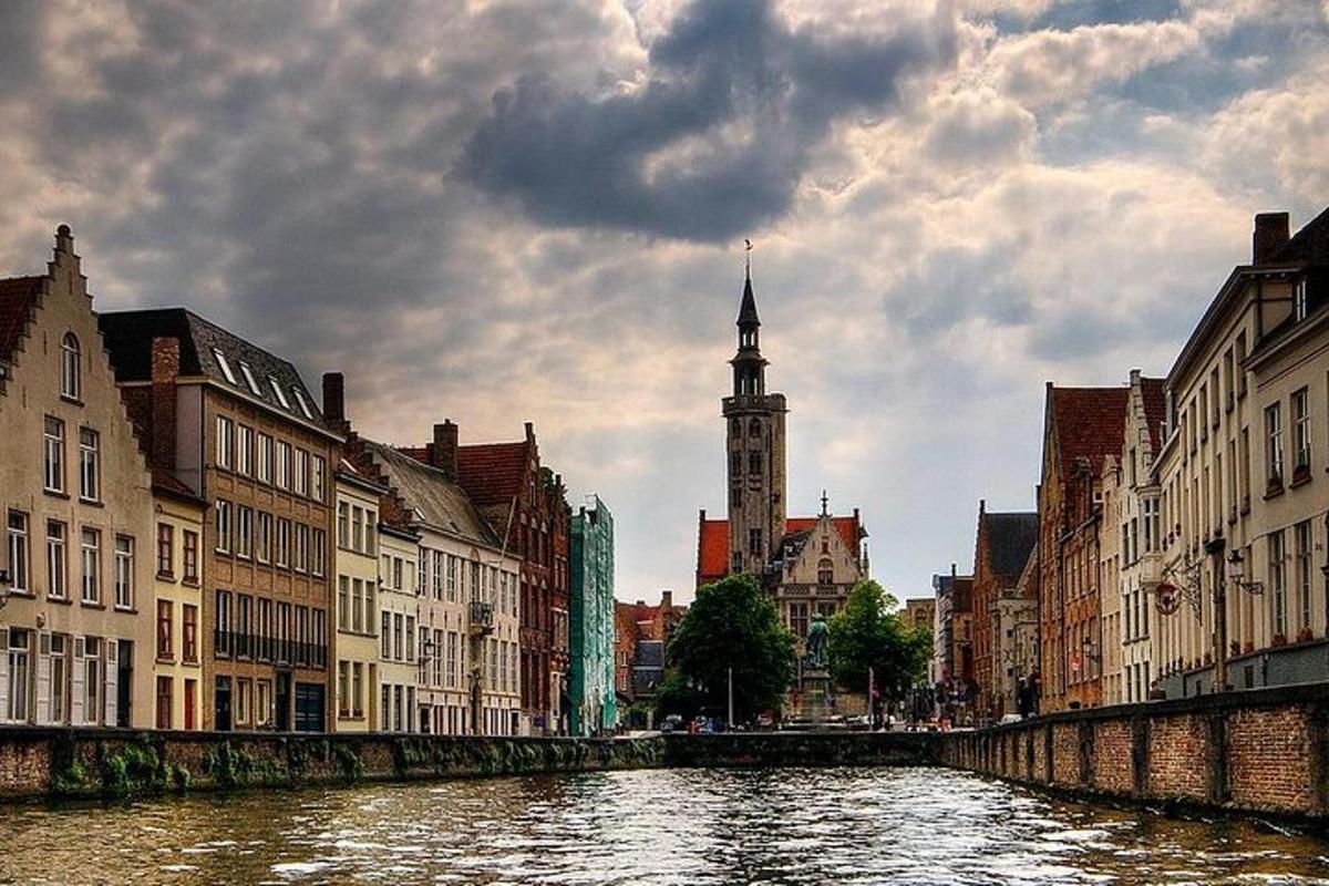 un fiume in una città con edifici e una torre dell'orologio