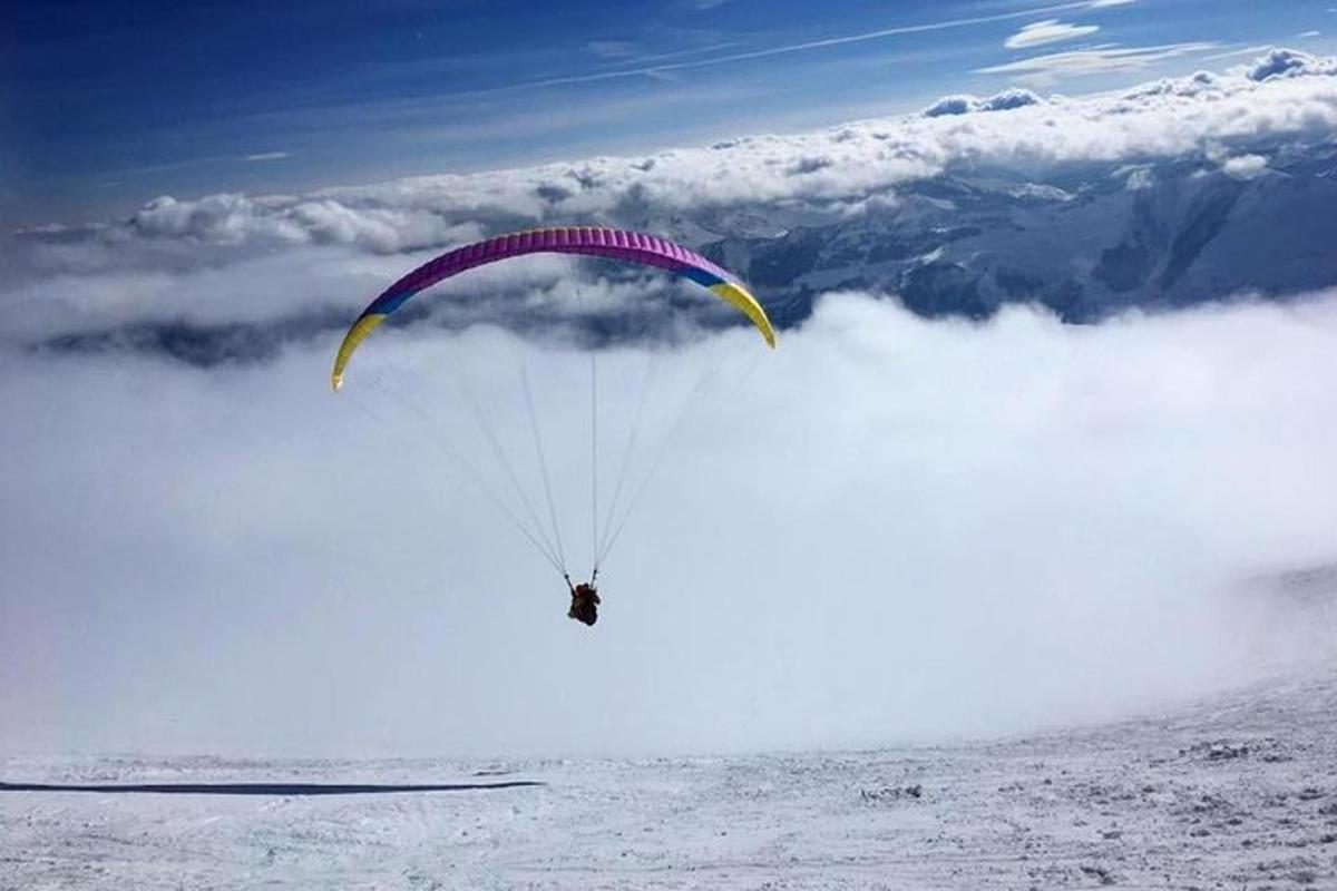 a person flying through the air with a parachute
