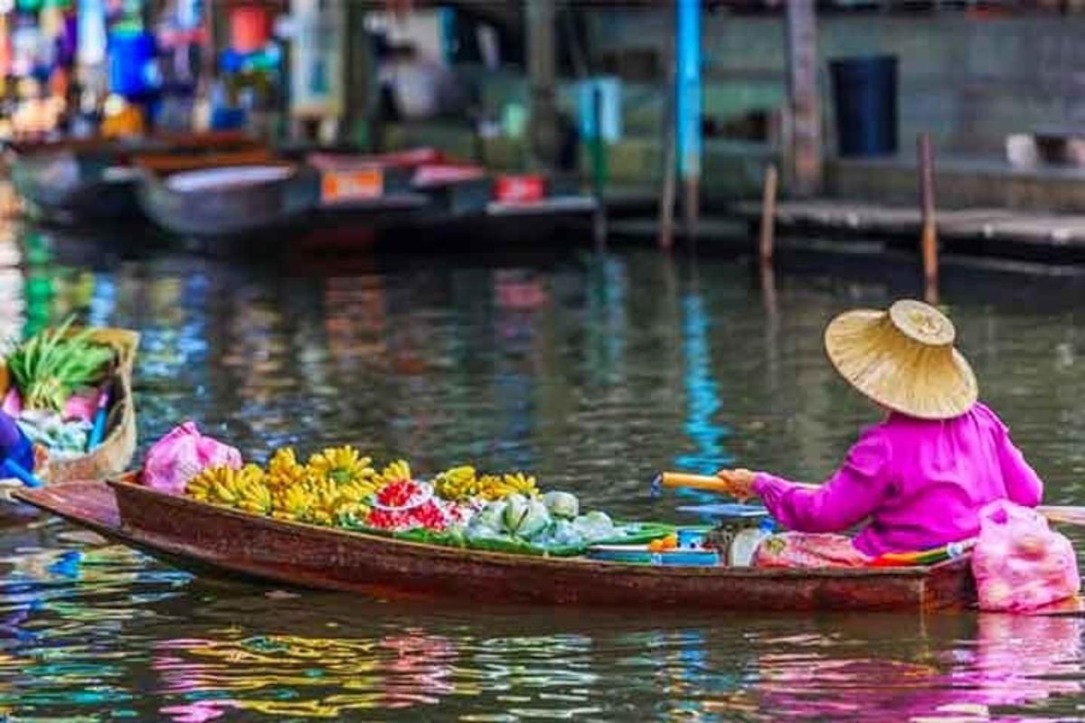 una persona en un bote con frutas y verduras en el agua