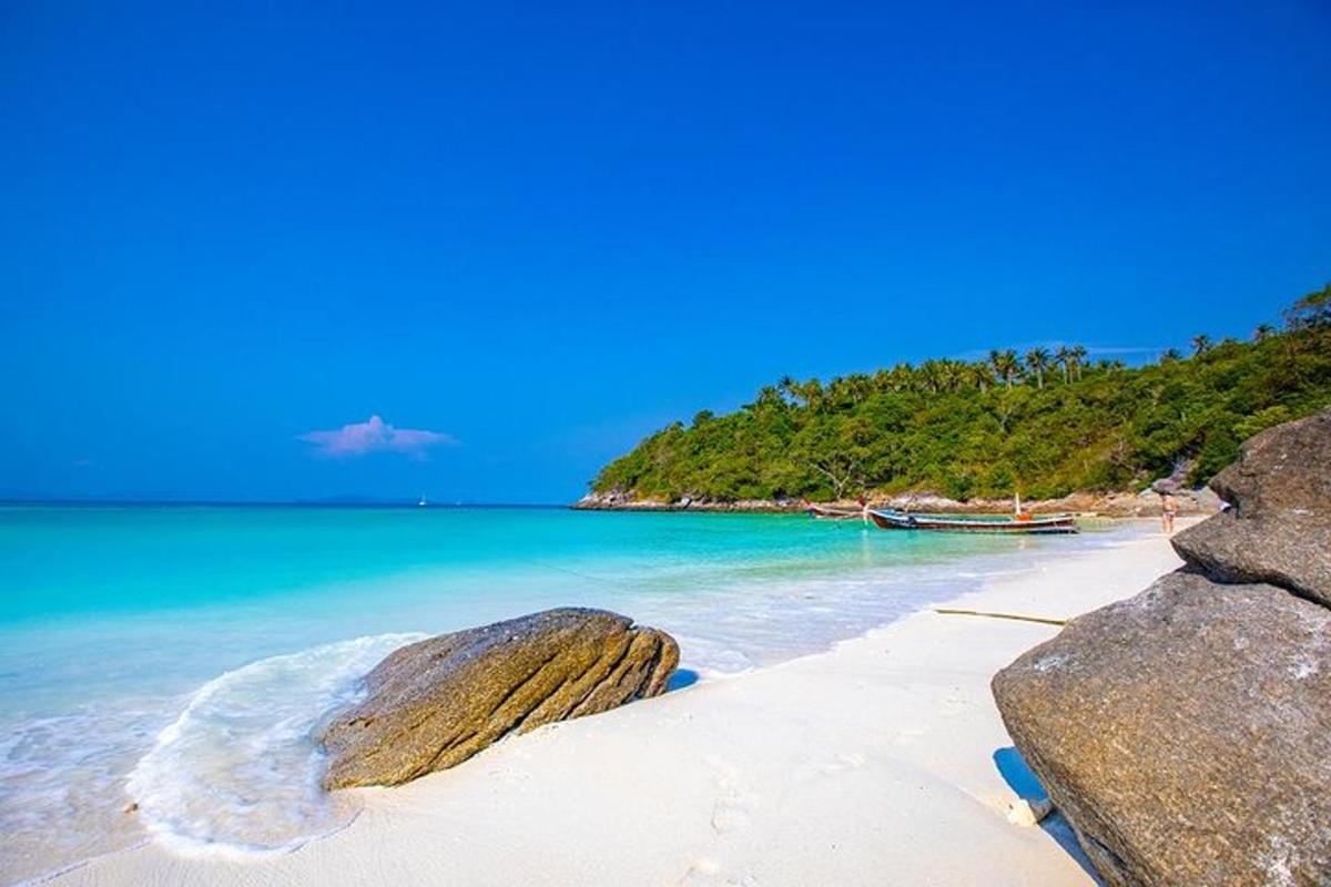 a beach with two large rocks and a boat in the water