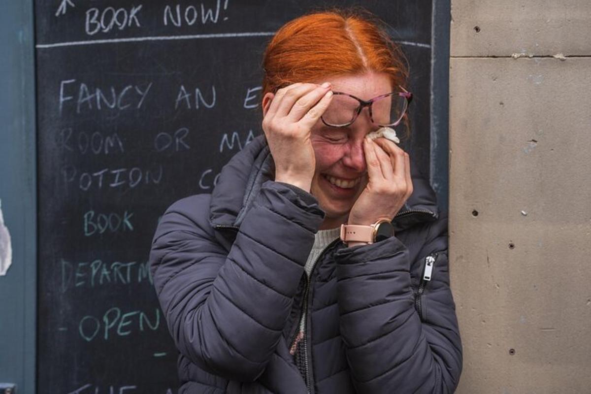 una donna con i capelli rossi si tiene le mani sul viso