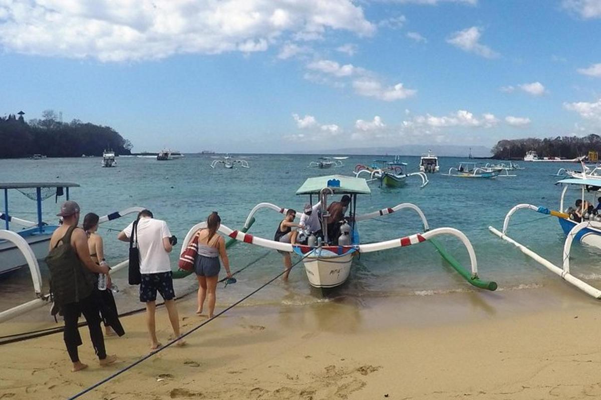 a group of people getting on a boat on the beach