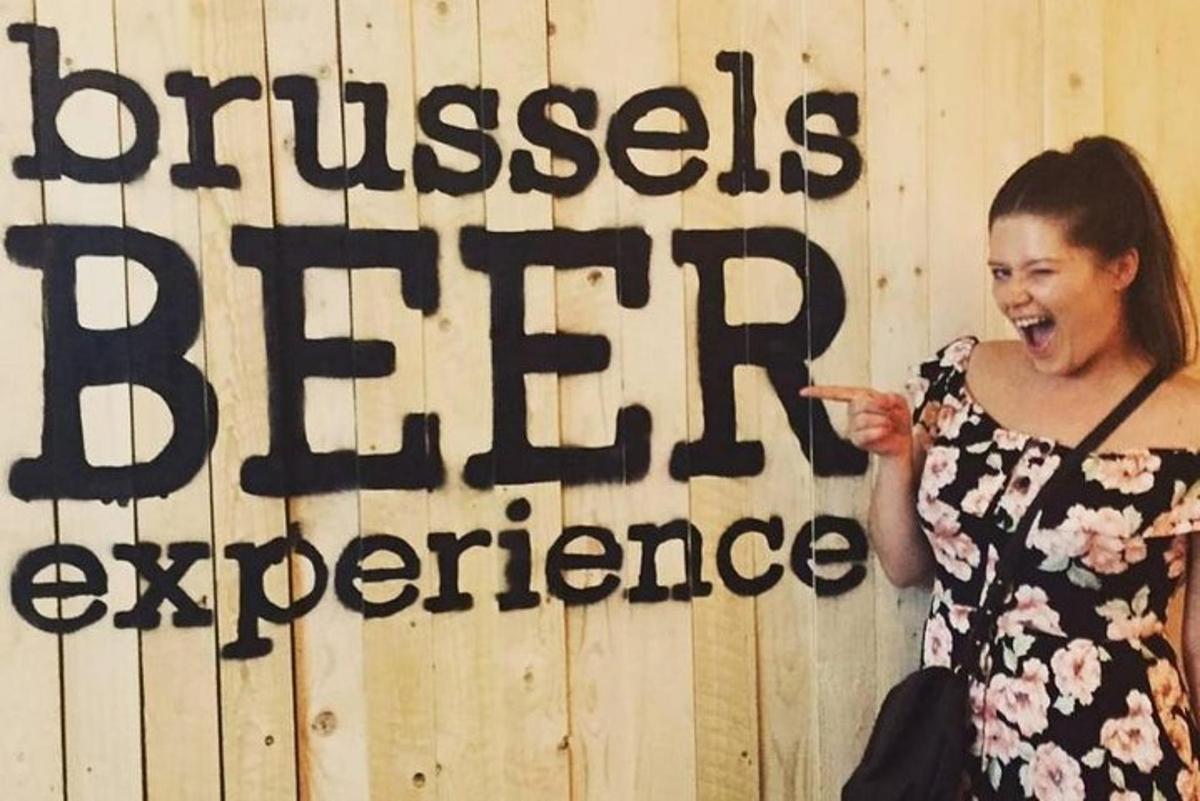 uma mulher em pé em frente a uma placa que diz "Sua experiência como curador"