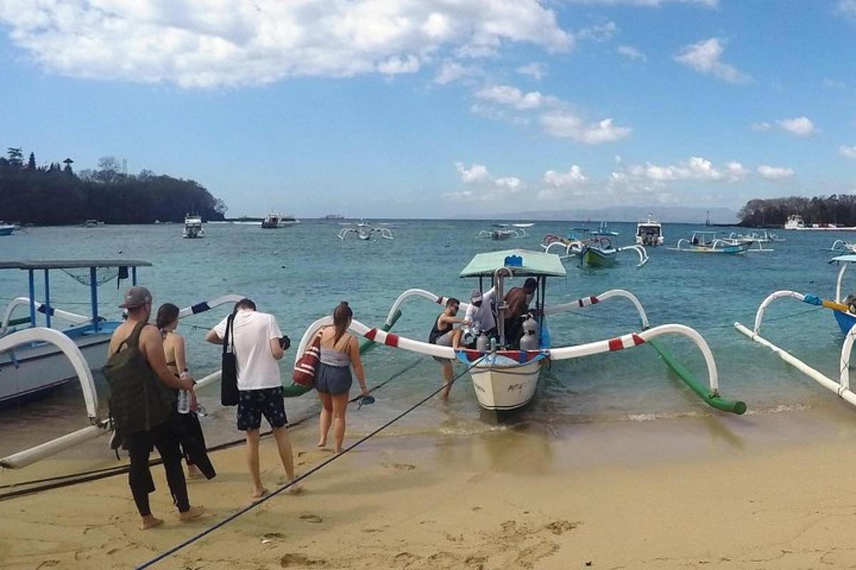 a group of people getting on a boat on the beach