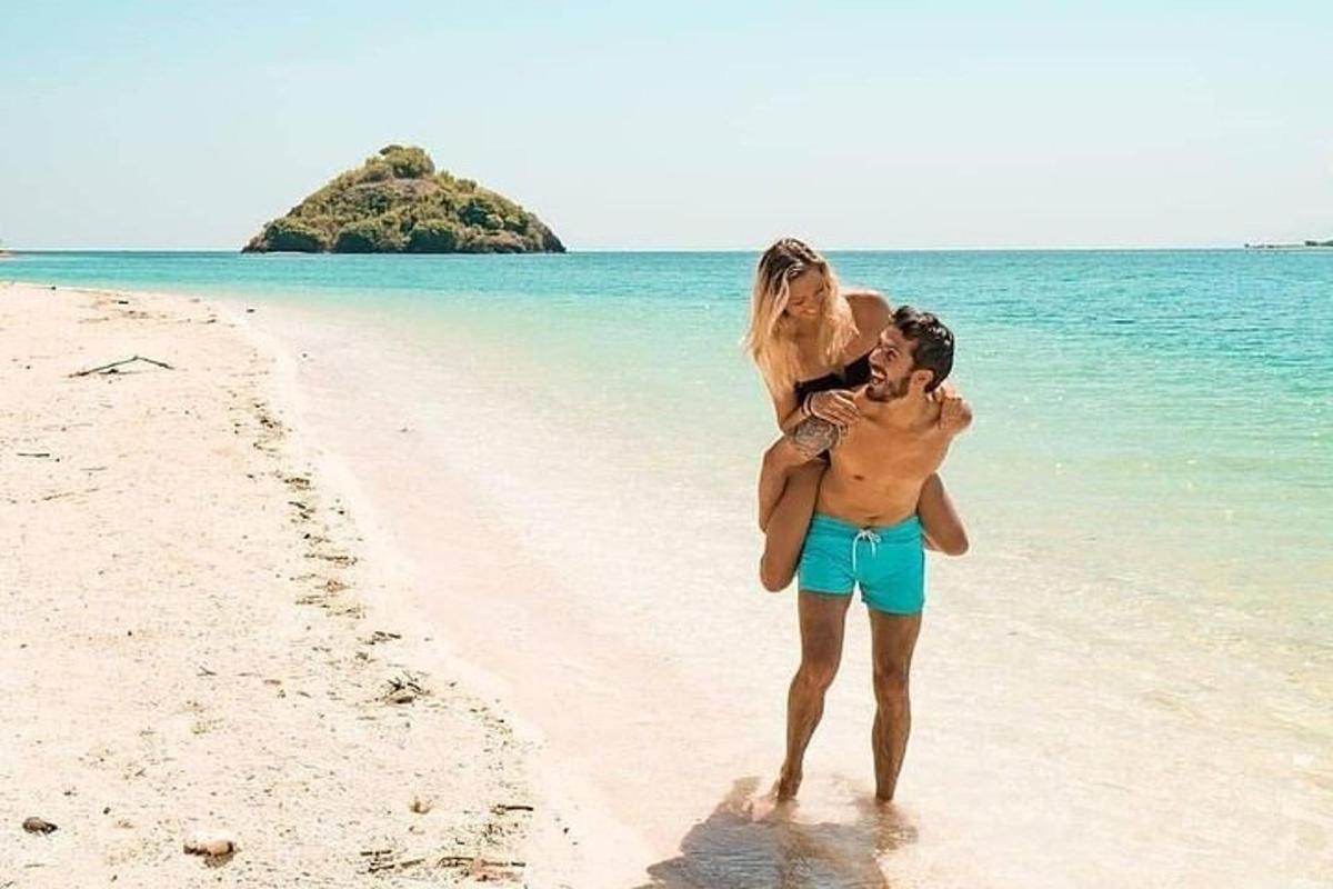 a man carrying a woman on a beach