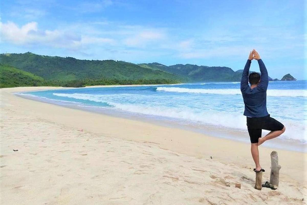 a person doing a yoga pose on the beach