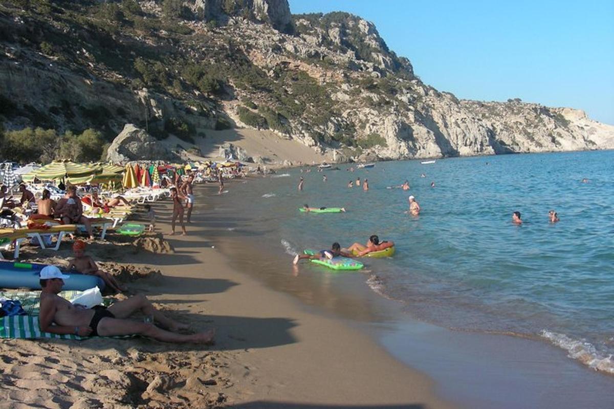 un grup de persones a la platja amb gent a l'aigua