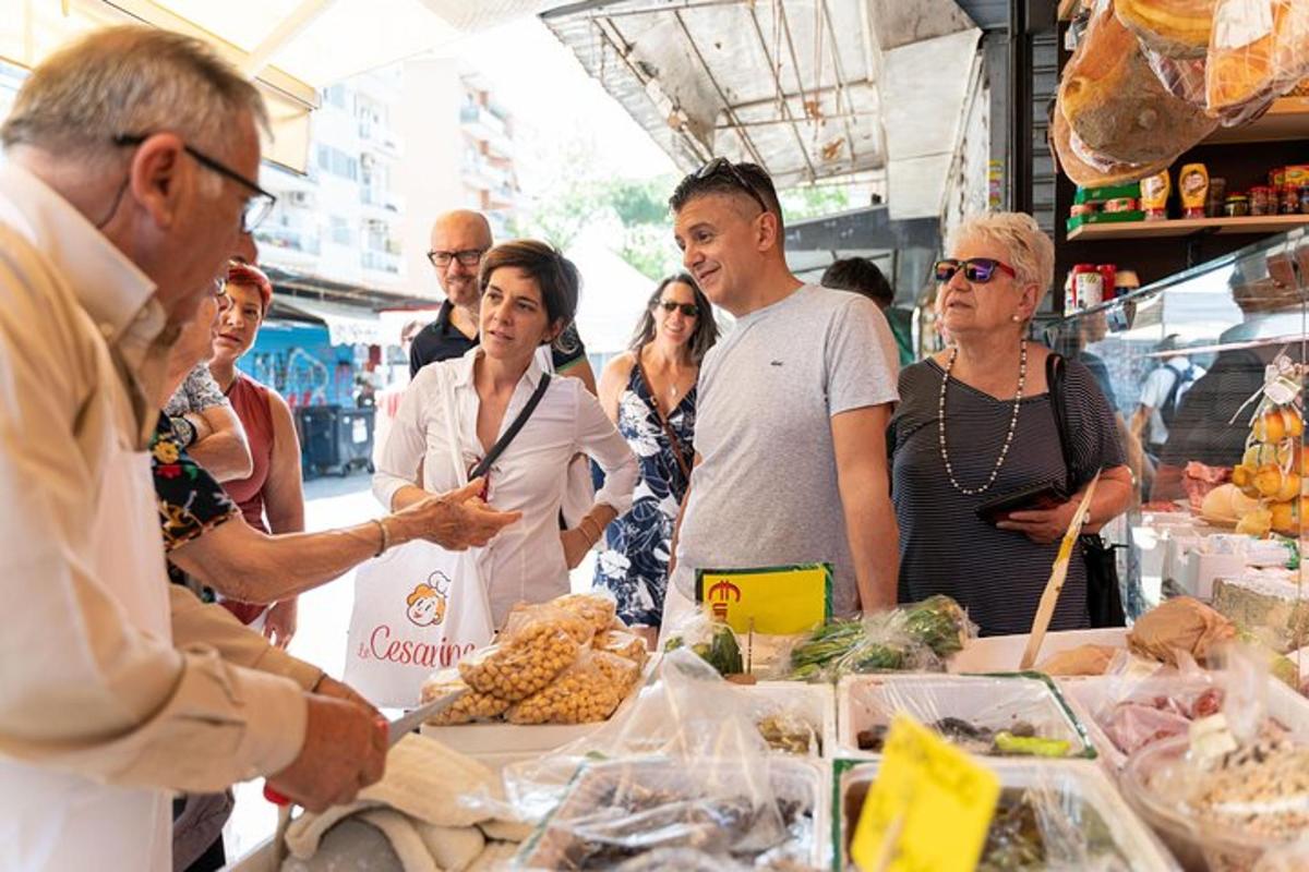 a group of people standing around a table with food