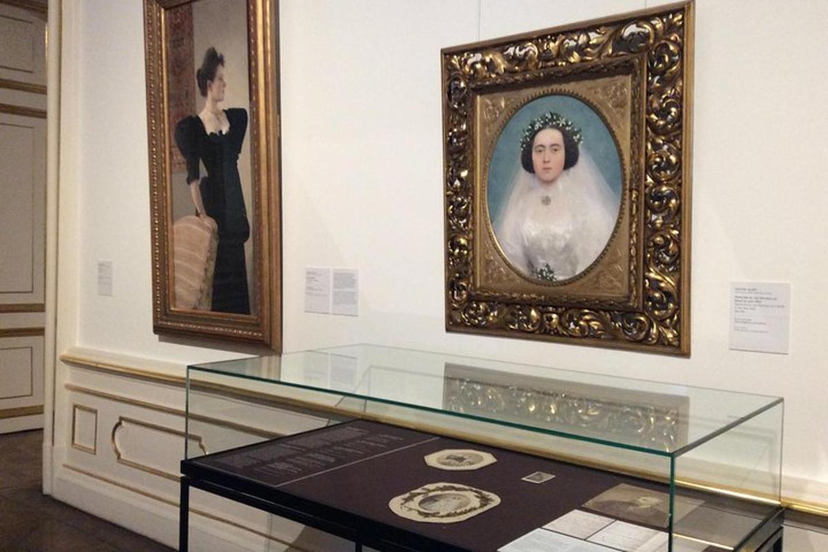 muzejní expozice s portrétem ženy a obrazem