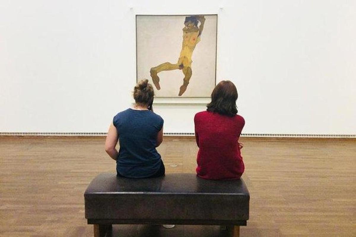 ベンチに座って絵を見ている2人の女性