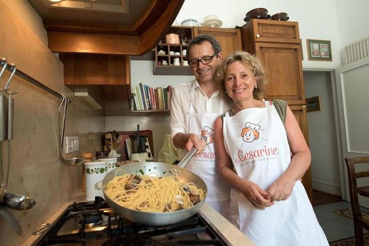 un uomo e una donna in piedi in una cucina che preparano la pasta