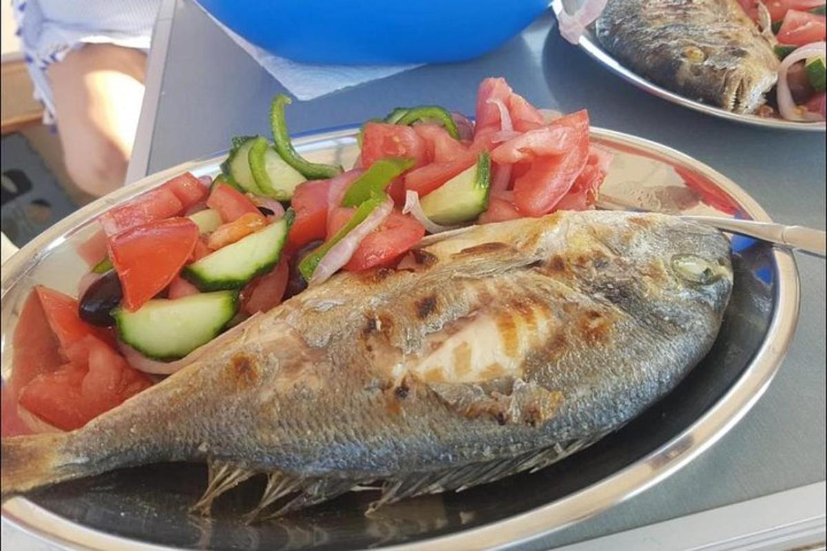 en tallerken med fisk og grønnsaker på et bord