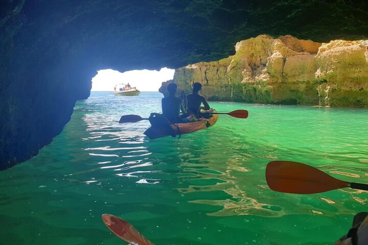 two people kayaking in the water in a cave