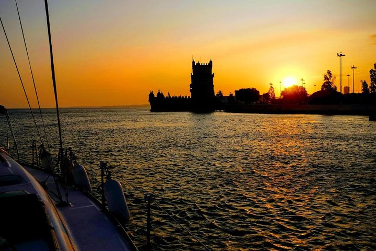un tramonto con una torre dell'orologio e una barca in acqua