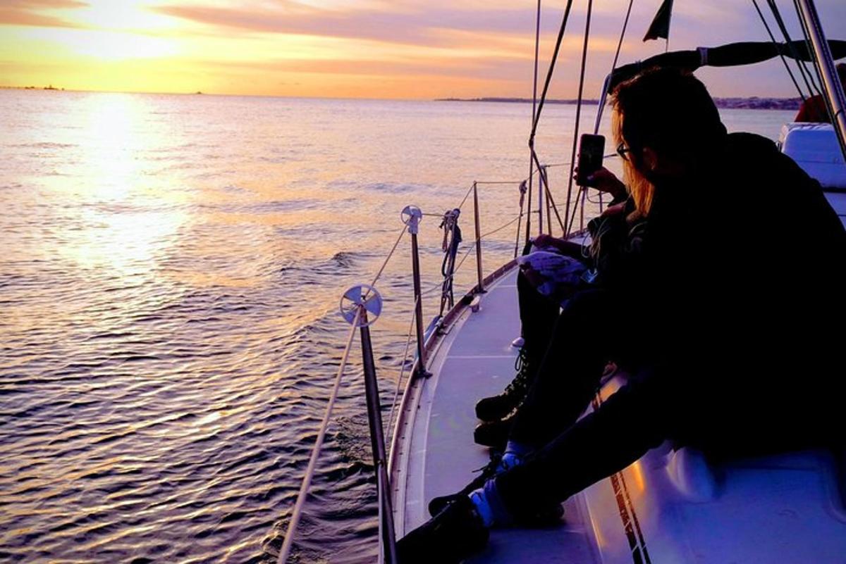 Una mujer tomando una fotografía de un barco en el agua.