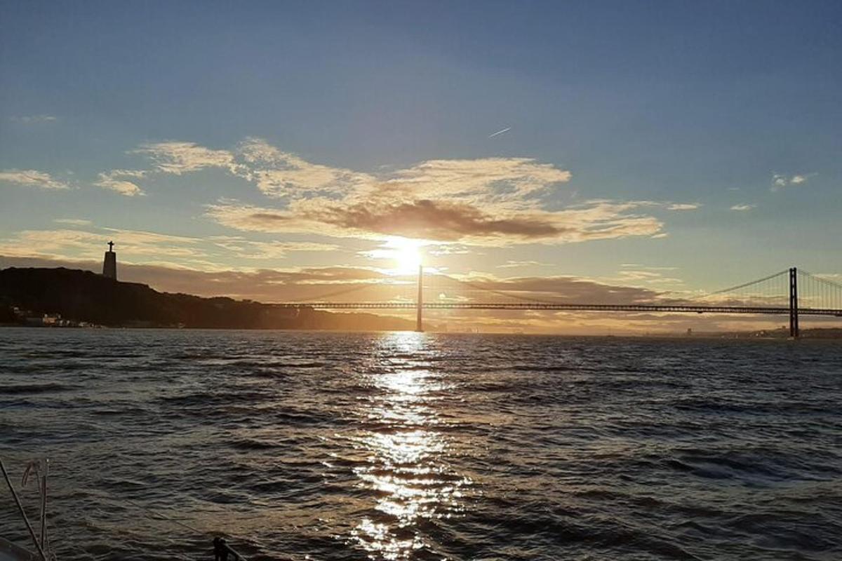 un tramonto sull'acqua con un ponte sullo sfondo