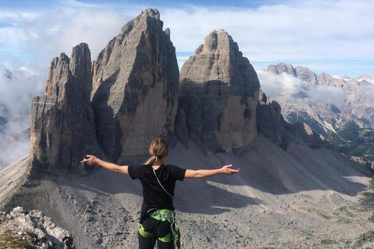 una donna in piedi sulla cima di una montagna con le braccia tese