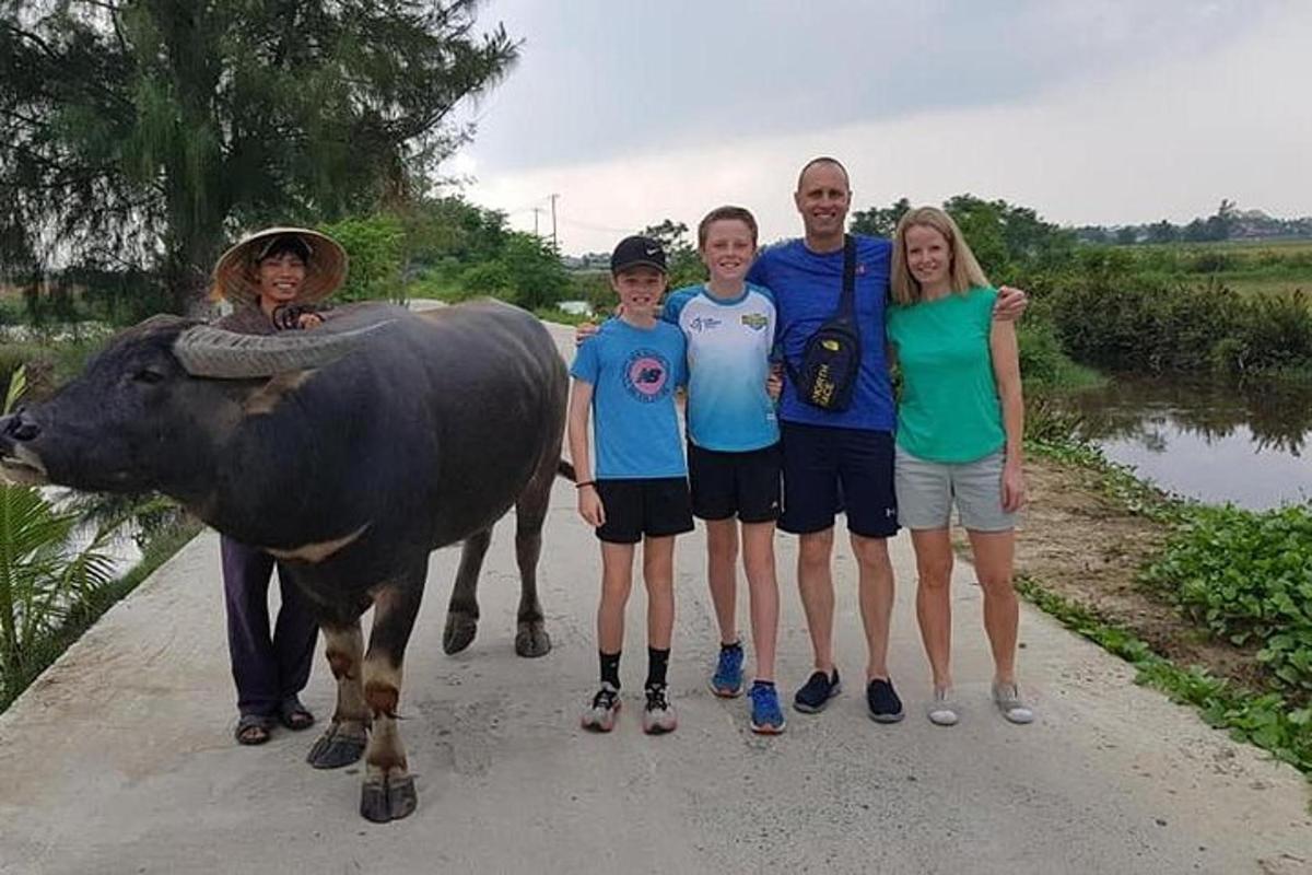 skupina lidí stojící vedle krávy