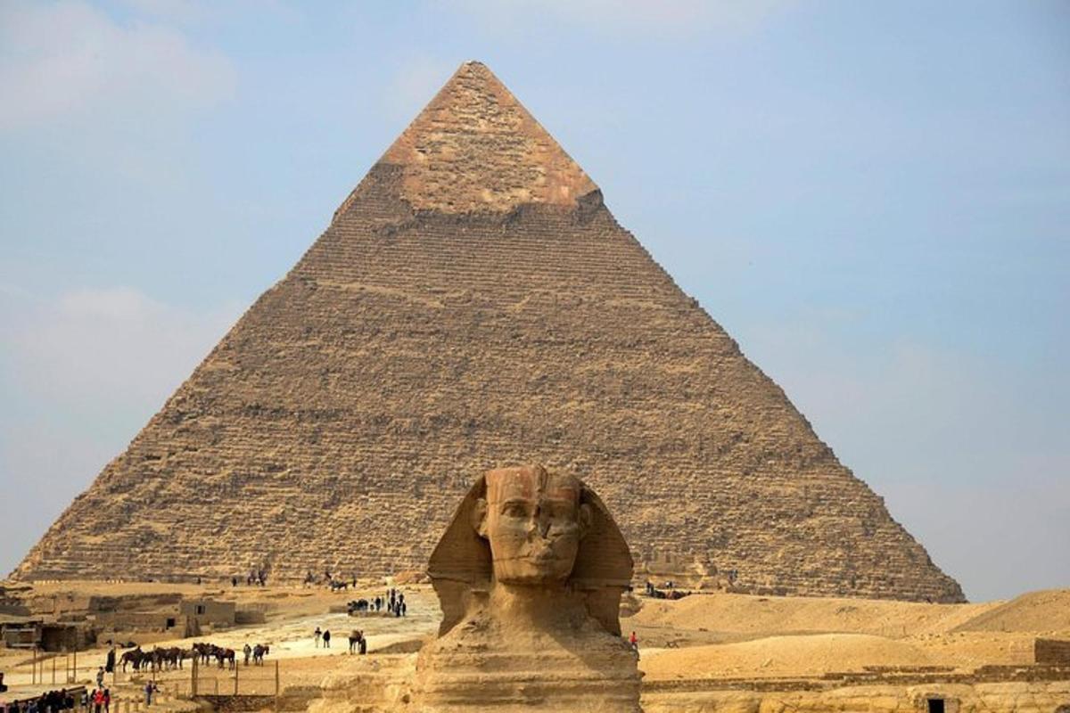 uma pirâmide e uma estátua em frente a uma pirâmide