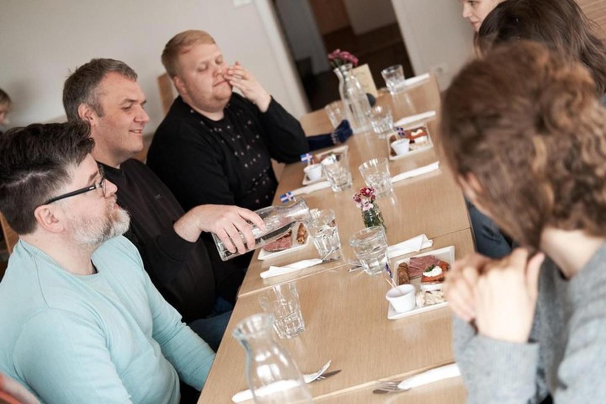 um grupo de pessoas sentadas ao redor de uma mesa comendo comida